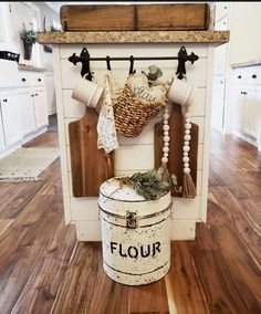 a kitchen with white cabinets and wooden flooring is decorated with decorative items on the wall