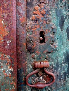 an old rusted metal door with a rusty handle