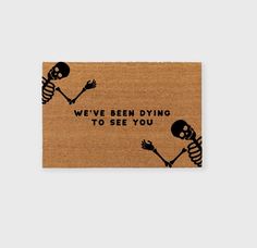 a door mat with two skeletons holding hands and the words we've been dying to see you