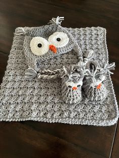 a crocheted owl blanket and two baby shoes