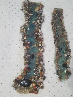 two pieces of glass with rocks and stones on them