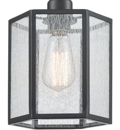 an outdoor light fixture with a glass shade on the front and side panels in black