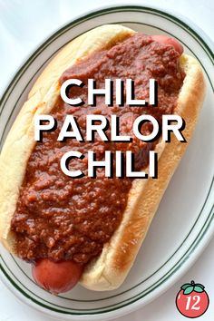 a chili hot dog on a plate with the words chilli parlor chili above it