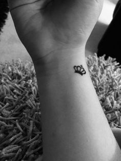 a black and white photo of a small wrist tattoo