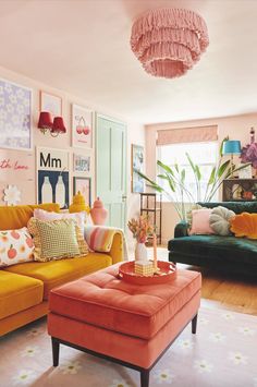 a living room filled with lots of furniture and colorful pillows on top of it's couches