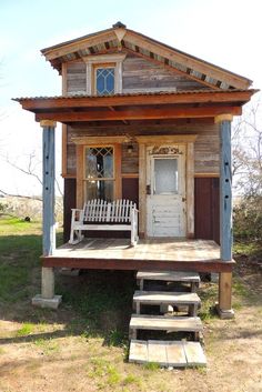 a small wooden house with steps leading up to it's front door and porch