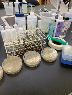 laboratory equipment sitting on top of a table next to beakers and containers filled with liquid