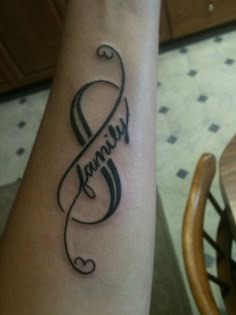 a tattoo with the word family on it's arm and an image of a ribbon