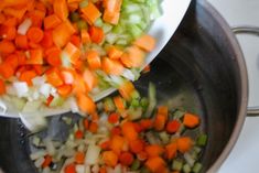 chopped carrots, celery and onions are in a pot on the stove