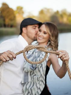 a man and woman standing next to each other with a rope in front of them