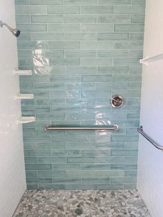 a walk in shower sitting next to a white toilet under a faucet mounted on a wall