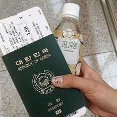 a person holding a passport and a bottle of water