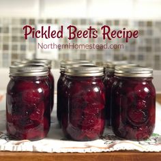 four jars filled with pickled beets sitting on top of a table