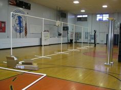 an empty gym with basketball hoop and boxes on the floor in front of it,