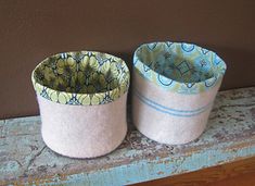 two pots sitting on top of a wooden shelf