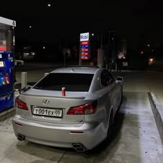 a silver car parked next to a gas pump