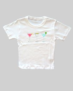 Martini Baby Tee   Women's T-Shirt | Girly Aesthetic | Y2K Trendy Shirt 🌟SHIRT This is a Bella+Canvas baby tee - the material is very soft and very high quality. 🌟SIZING Please find the size chart in listing photo before purchasing. We recommended measuring a t-shirt you already own to get the best fitting t-shirt. 💖CARE/ WASH Machine wash: warm (max 40C or 105F); Non-chlorine: bleach as needed Tumble dry: medium heat; Iron, steam or dry: low heat; Do not dry clean. ✨SHIPPING Your items usually will ship in 2-7 business days. Products shipped from US.  Thanks for shopping small.  Please let me know if you need any custom designs or bulk orders that is not listed, I'll happily custom-make it for you! ♡ Playful White Fitted Top, Playful Fitted White Top, Cute Fitted Pre-shrunk T-shirt, Unisex Summer Birthday T-shirt, Fitted White T-shirt With Funny Print, Playful Fitted Short Sleeve T-shirt, Fitted White Fun Top, Unisex Playful Short Sleeve Shirt, Graphic Tee With Short Sleeves For Birthday