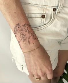 a woman's arm with a horse tattoo on the left side of her wrist