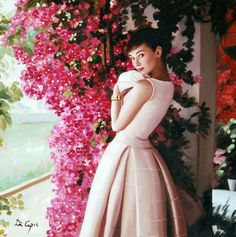 a woman in a pink dress standing next to flowers