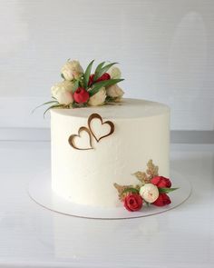 a white cake with flowers and hearts on it