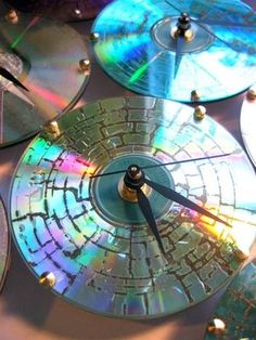 several cds are stacked on top of each other with the same clock in front of them