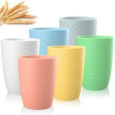 four different colored cups are shown with wheat in the foreground and on the background