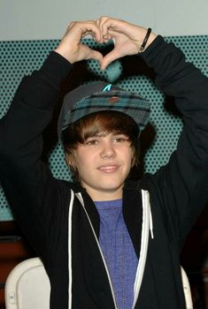 a boy making a heart with his hands