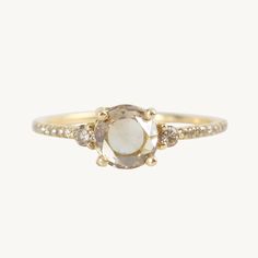 a gold ring with an oval stone surrounded by small diamonds