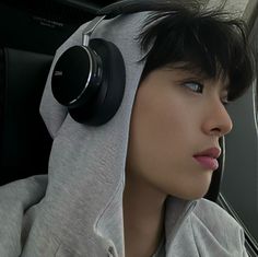 a person with headphones on sitting in a car and looking off into the distance