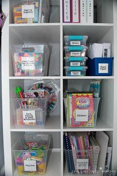 a white bookcase filled with lots of books and plastic containers on top of it