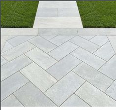 a stone walkway with grass in the background