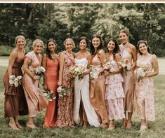 a group of women standing next to each other in front of trees and grass on a field