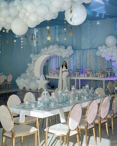 a woman standing in front of a table filled with white balloons