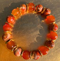 This beautiful carnelian and orange imperial jasper bracelet is a great gift for yourself or a special person in your life! Carnelian provides bold energy. Orange imperial jasper stimulates enthusiasm and creativity. Handmade with 10mm carnelian, 10mm orange imperial jasper, 9mm decorative gold tone chip spacers and durable stretch cord, bracelet length can be customized - just specify your preferred length in the order notes.  Visit our shop's Bracelets section for the full collection with a variety of colorful options. This one-of-a-kind jewelry works with a wide range of outfits - whether casual or more dressed up.  All of our pieces are hand assembled in our design studio with careful attention to detail and durability.  Every order arrives gift wrapped in our signature box.  Orders sh Cheap Cute Orange Beaded Bracelets, Luxury Artisan Orange Beads, Unique Luxury Orange Beads, Circle Jewelry, Orange Bracelet, Carnelian Bracelet, Imperial Jasper, Jewelry Words, Jasper Bracelet