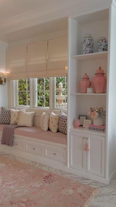 a living room filled with lots of furniture and decor on top of a pink rug