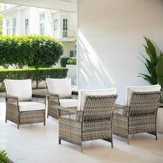 an outdoor patio with wicker furniture and potted plants