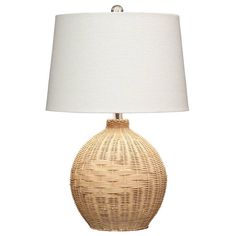 a wicker table lamp with a white shade