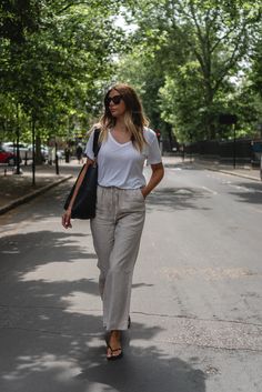 Emma Hill wears white v neck t-shirt, beige linen trousers, Sleepers black flip flops, Celine Seau Sangle bag in black. Casual Summer outfit How To Wear Linen Pants, Celine T Shirt, Linen Pants Outfit Ideas, Linen Trousers Outfit, Beige Pants Outfit, Basics Outfit, Linen Shirt Outfit, Beige Linen Pants, Emma Hill