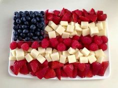 an american flag made out of strawberries and blueberries on a white platter