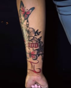 a woman's arm with a butterfly and flower tattoo on the left side of her arm