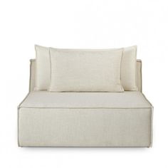 a white couch with two pillows on the back and one pillow in the middle, against a