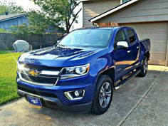 a blue truck parked in front of a house