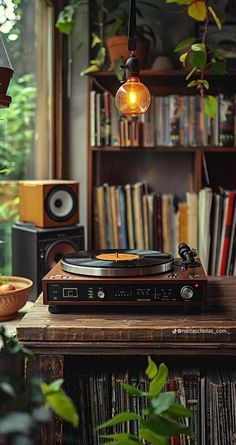 a record player sitting on top of a wooden table in front of a bookshelf