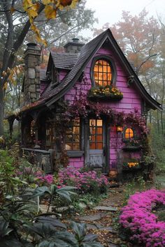 a small purple house with flowers around it