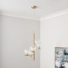 a modern chandelier hanging from the ceiling in a dining room with white walls