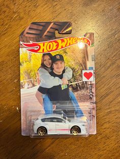 a hot wheels car with a couple on it's back in a carded package