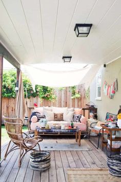 an outdoor living area with furniture and decor on the deck, covered in wood planks