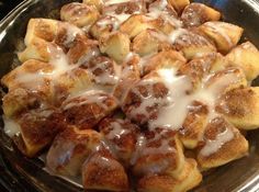 cinnamon rolls with icing in a glass dish