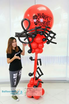 a woman standing in front of a balloon sculpture