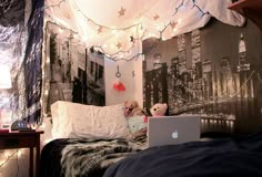 a laptop computer sitting on top of a bed in a room filled with string lights